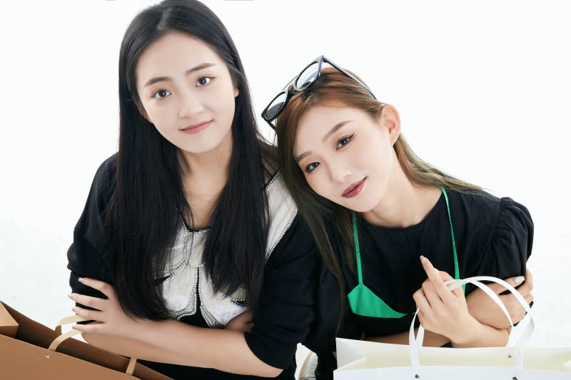 白色背景下手提购物袋时尚美丽的闺蜜