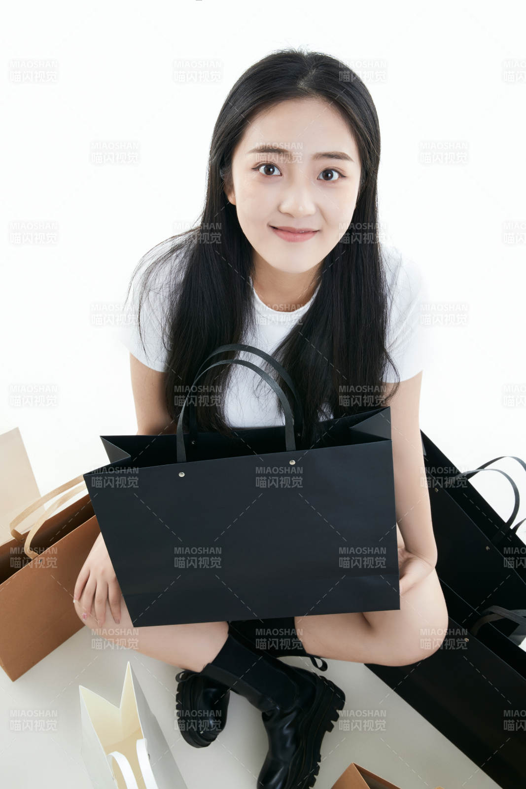 白色背景下手提購(gòu)物袋時(shí)尚美麗的亞洲少女