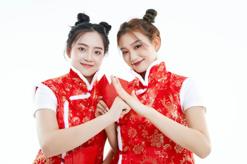 白色背景下身穿喜庆服饰的中国可爱少女