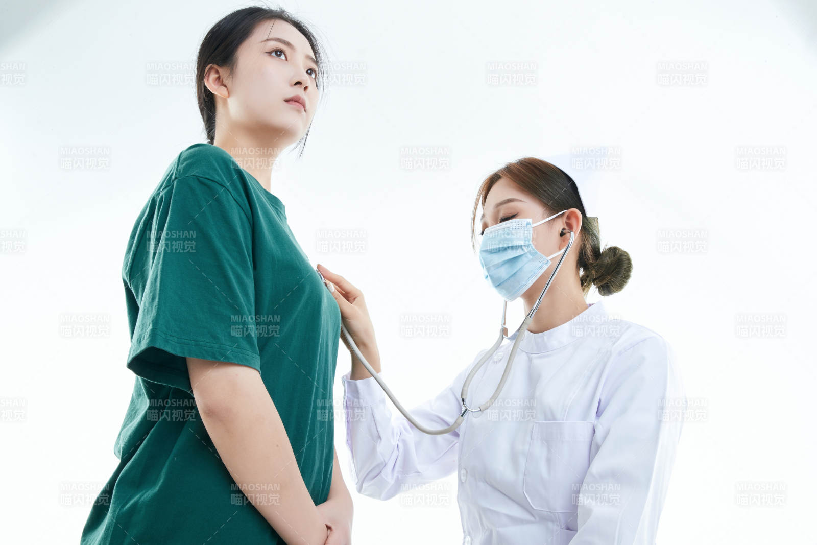 佩戴聽診器的女性醫護人員為患者聽診檢查