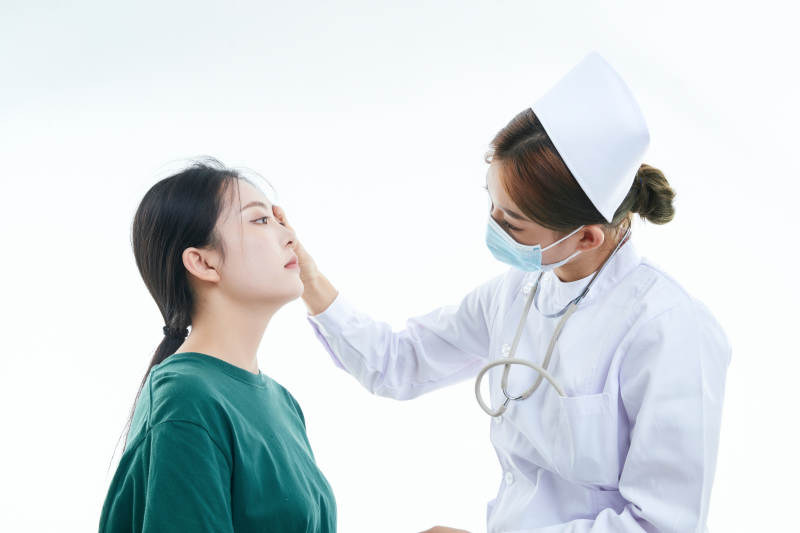 佩戴听诊器的女性医护人员为患者听诊检查