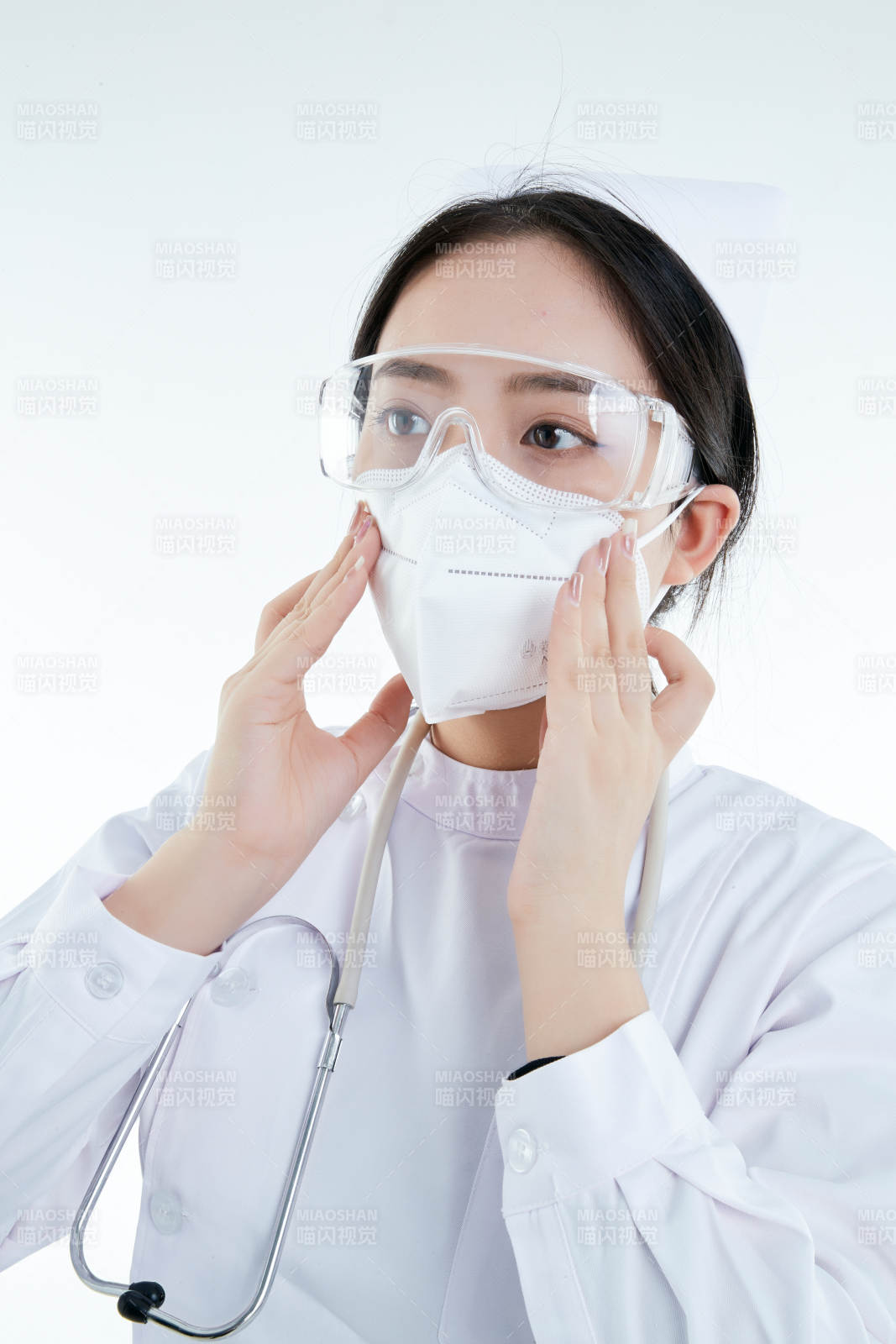 女性醫(yī)護人員展示規(guī)范的口罩正確佩戴方式