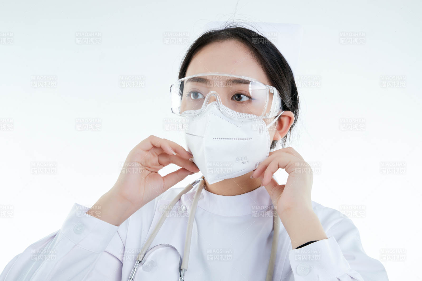 女性醫(yī)護人員展示規(guī)范的口罩正確佩戴方式