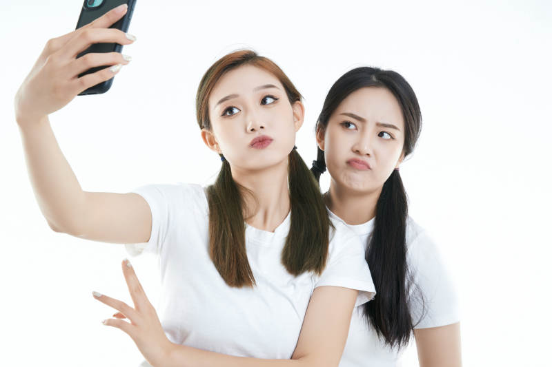 使用手机自拍的亚洲可爱闺蜜少女