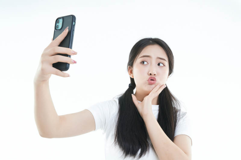 使用手机的亚洲可爱少女