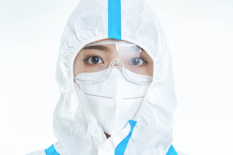 穿白色防护服佩戴护目镜口罩的女性医疗人员