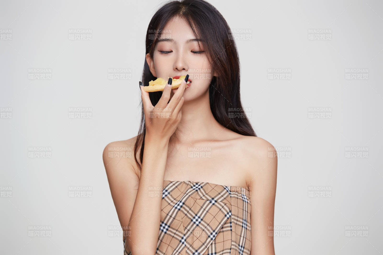 白色背景下吃著美味榴蓮披薩的可愛少女