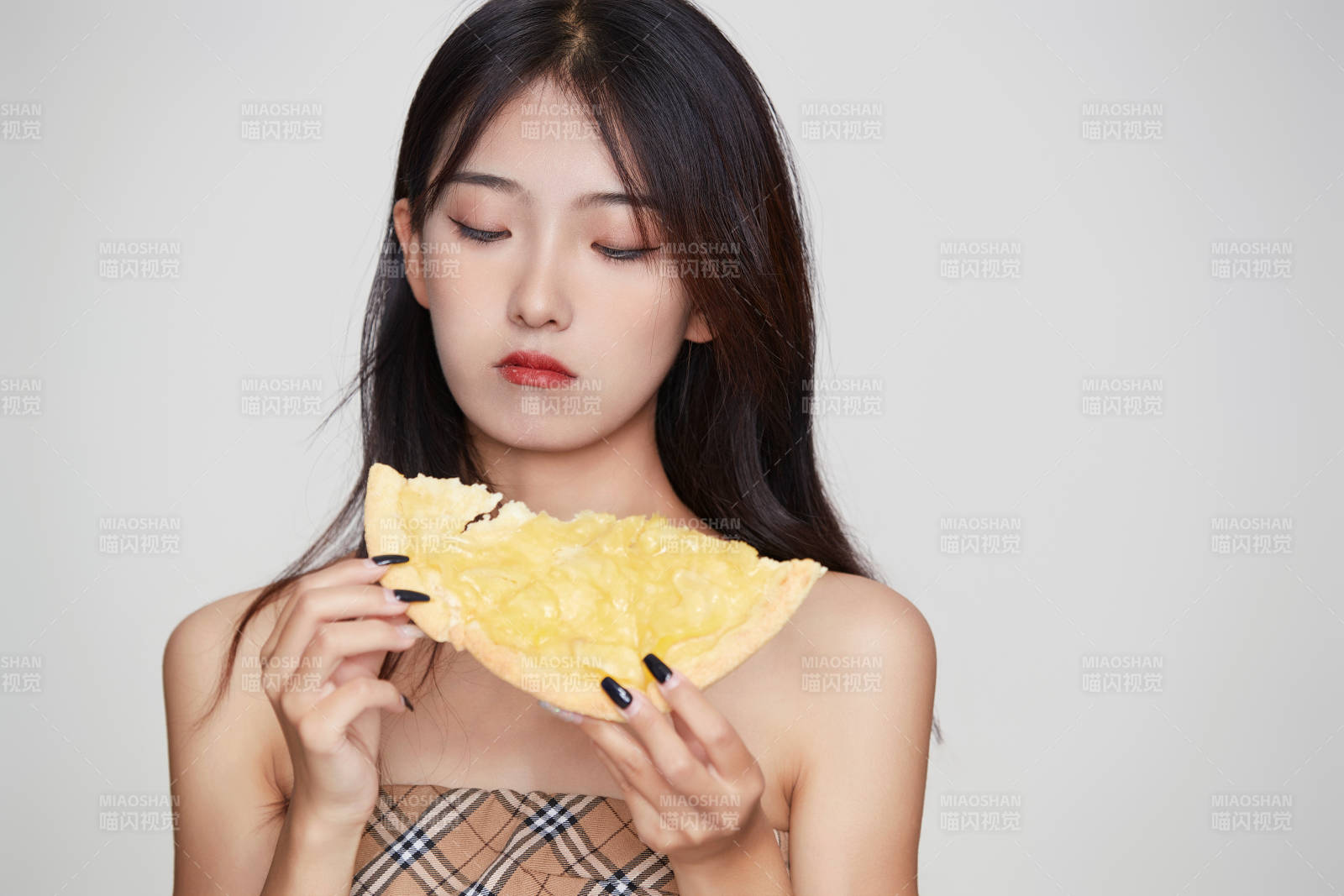 白色背景下吃著美味榴蓮披薩的可愛少女