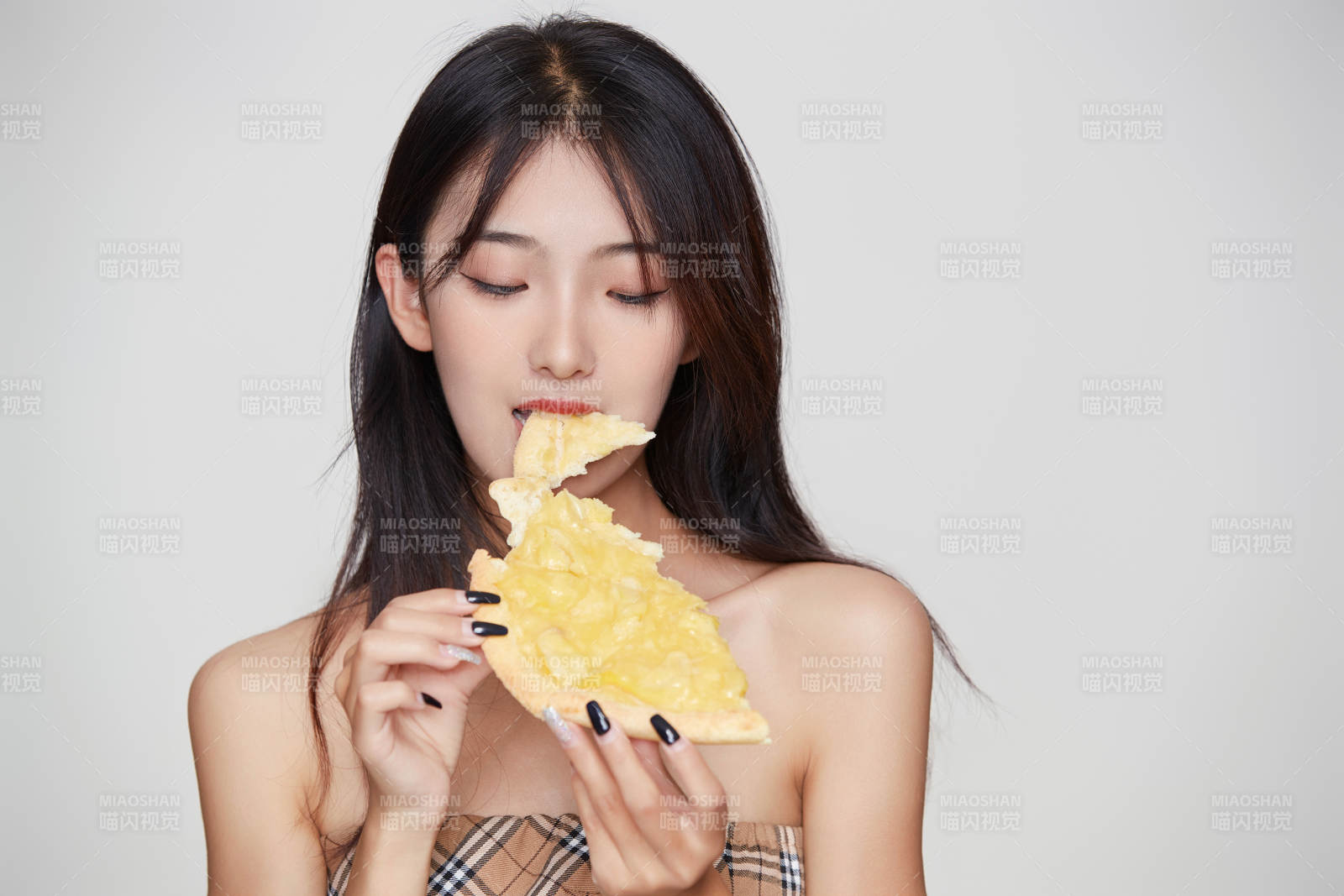 白色背景下吃著美味榴蓮披薩的可愛少女