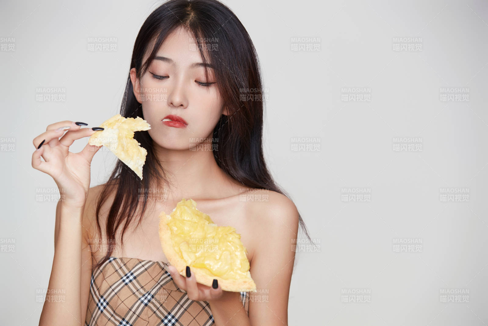 白色背景下吃著美味榴蓮披薩的可愛少女