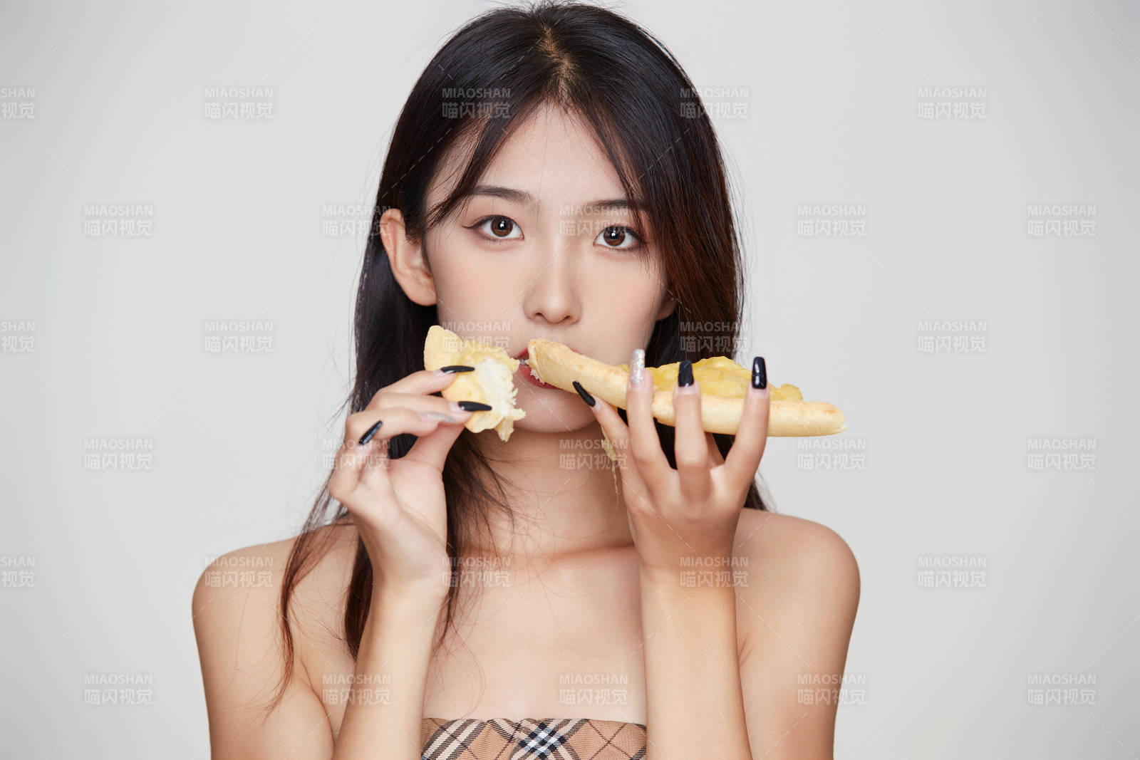 白色背景下吃著美味榴蓮披薩的可愛少女