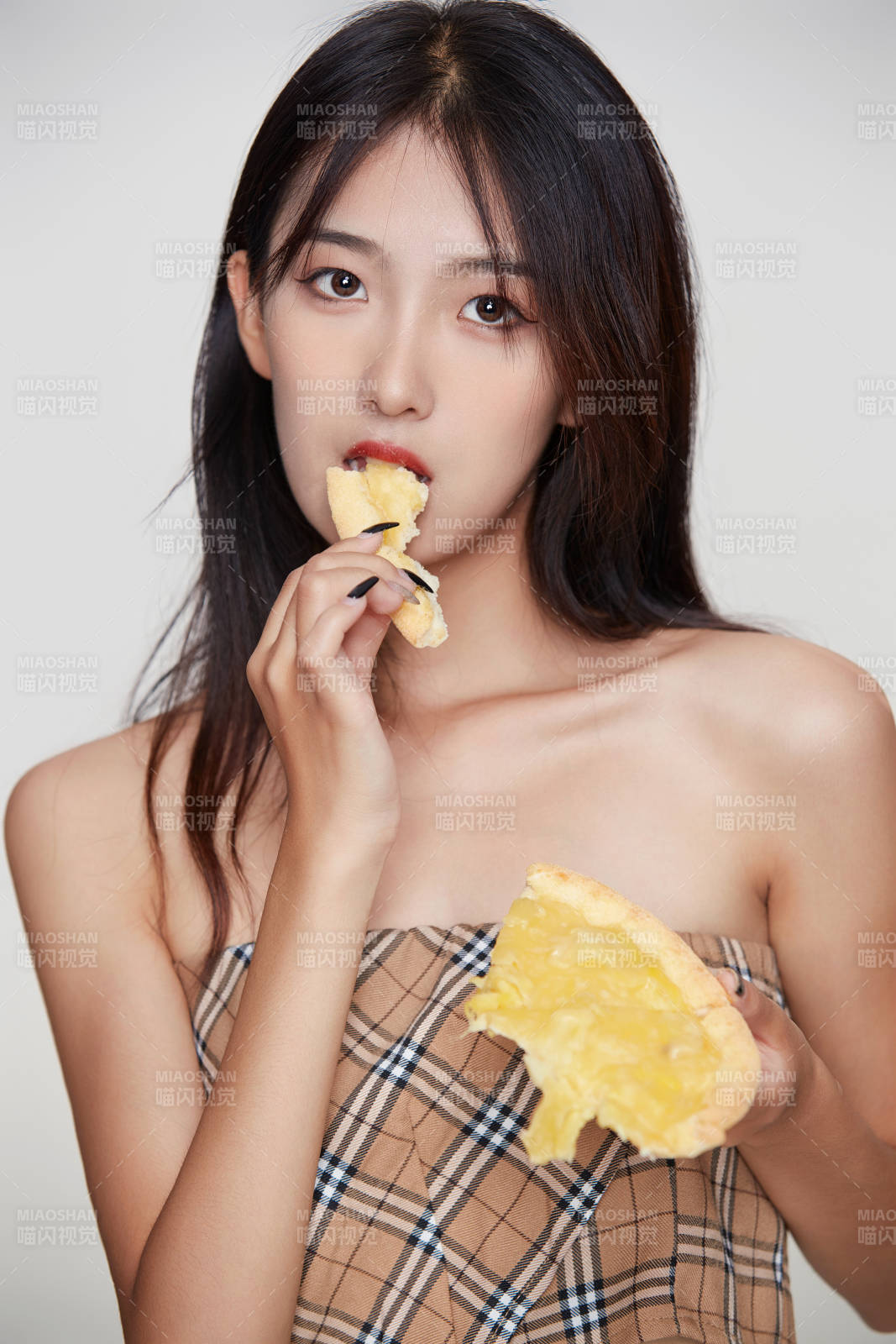 白色背景下吃著美味榴蓮披薩的可愛少女