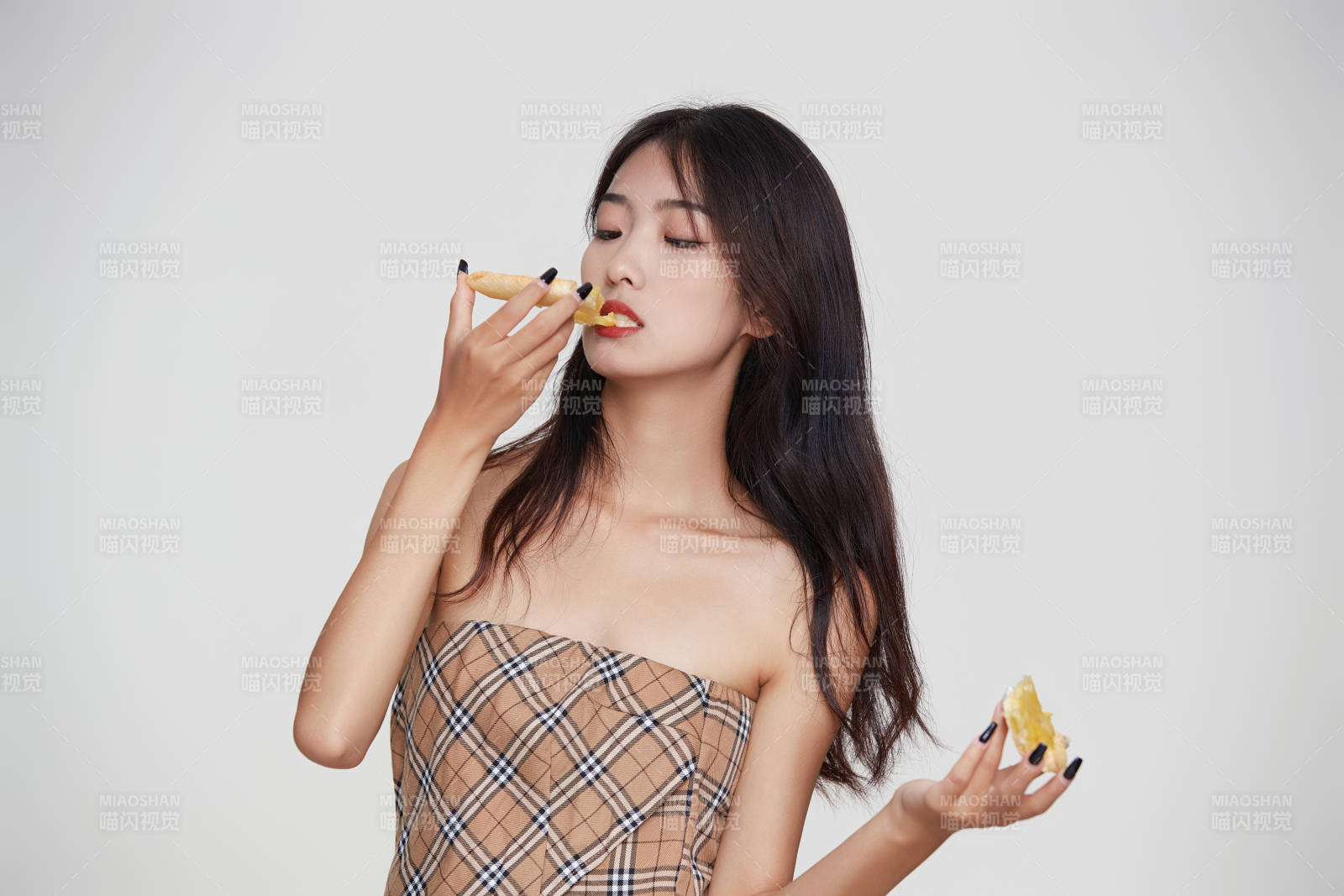 白色背景下吃著美味榴蓮披薩的可愛少女