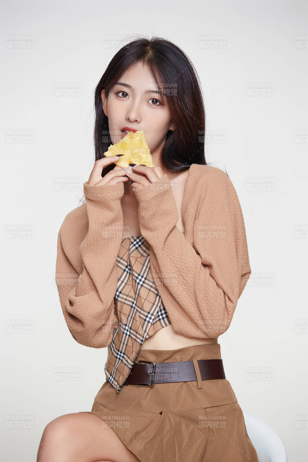 白色背景下吃著美味榴蓮披薩的可愛少女