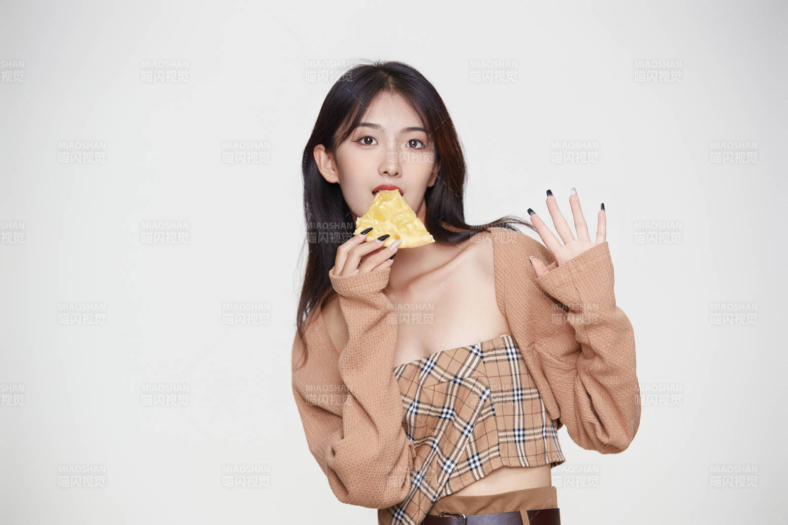 白色背景下吃著美味榴蓮披薩的可愛少女