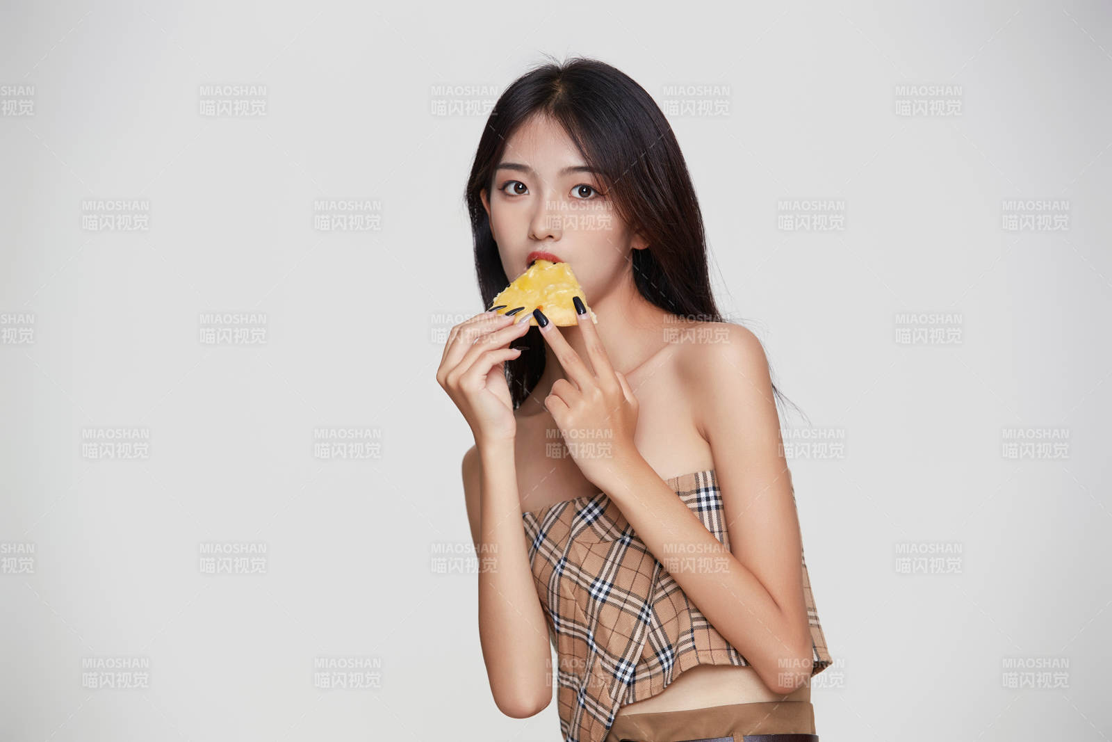 白色背景下吃著美味榴蓮披薩的可愛少女