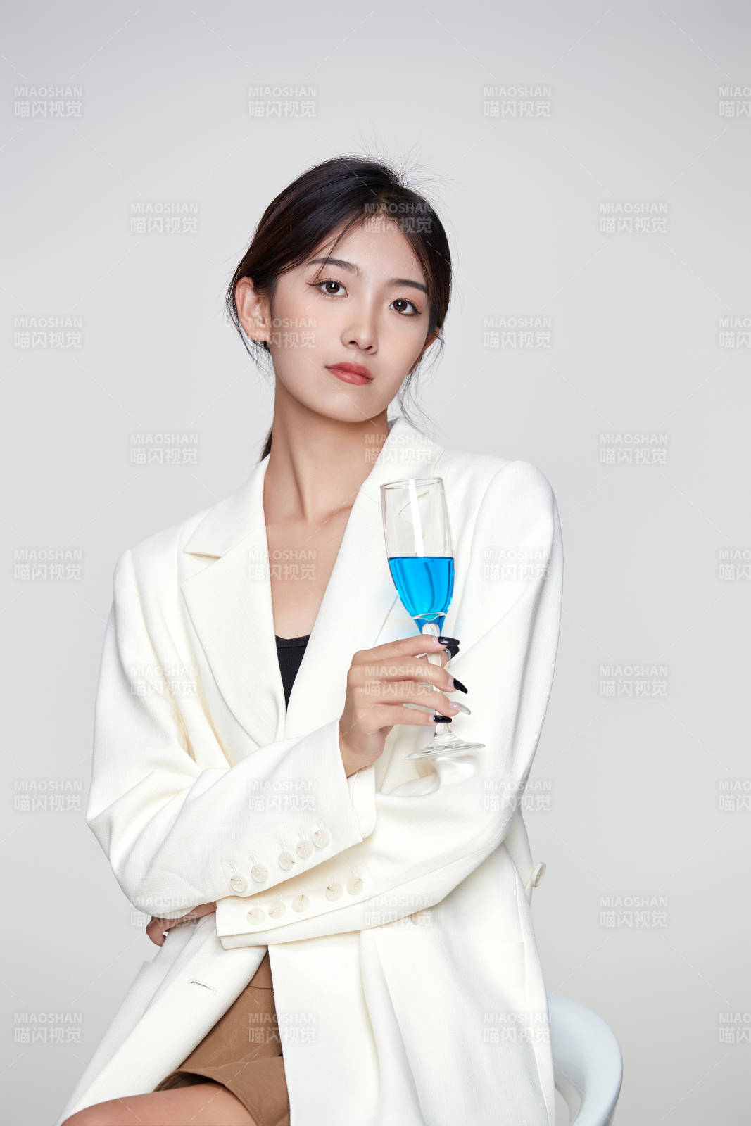 坐在椅子上手端酒杯的亞洲商務女性