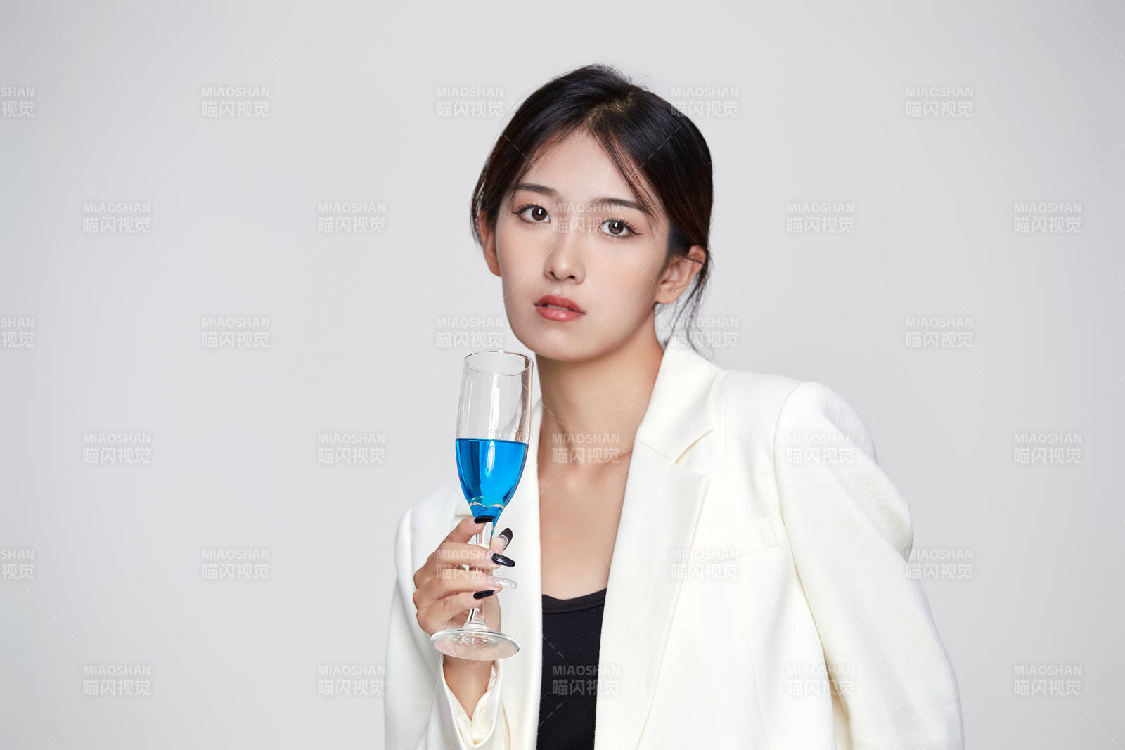 坐在椅子上手端酒杯的亞洲商務女性