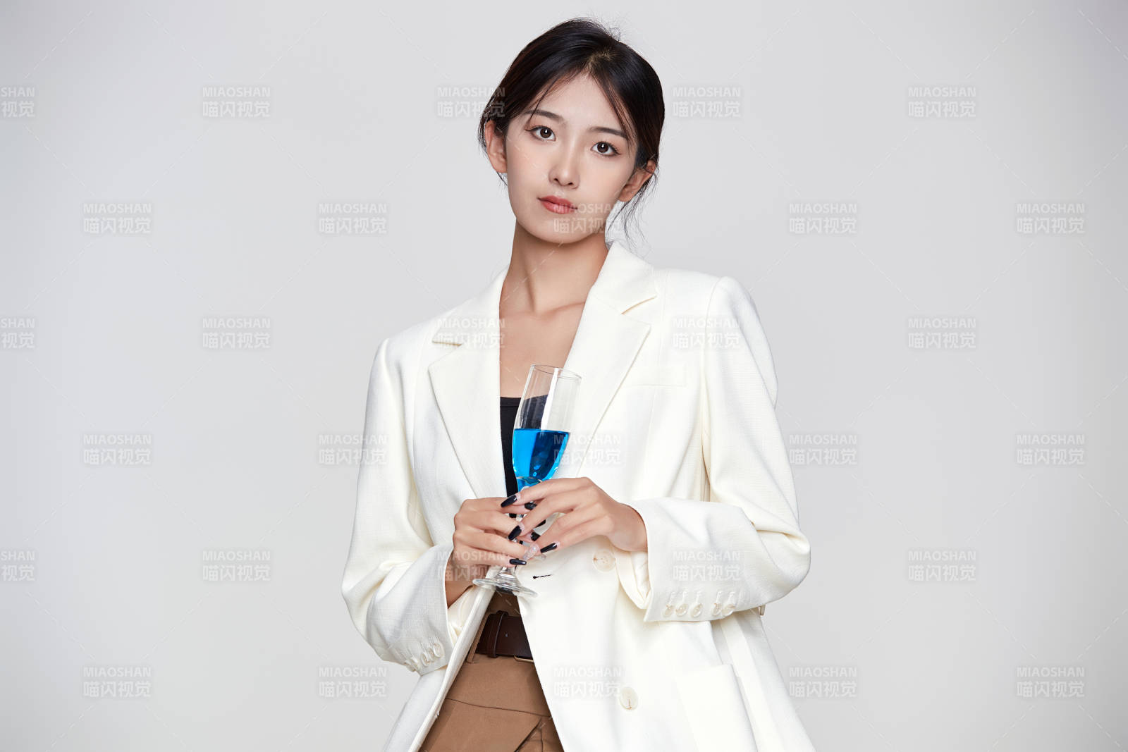 坐在椅子上手端酒杯的亞洲商務女性