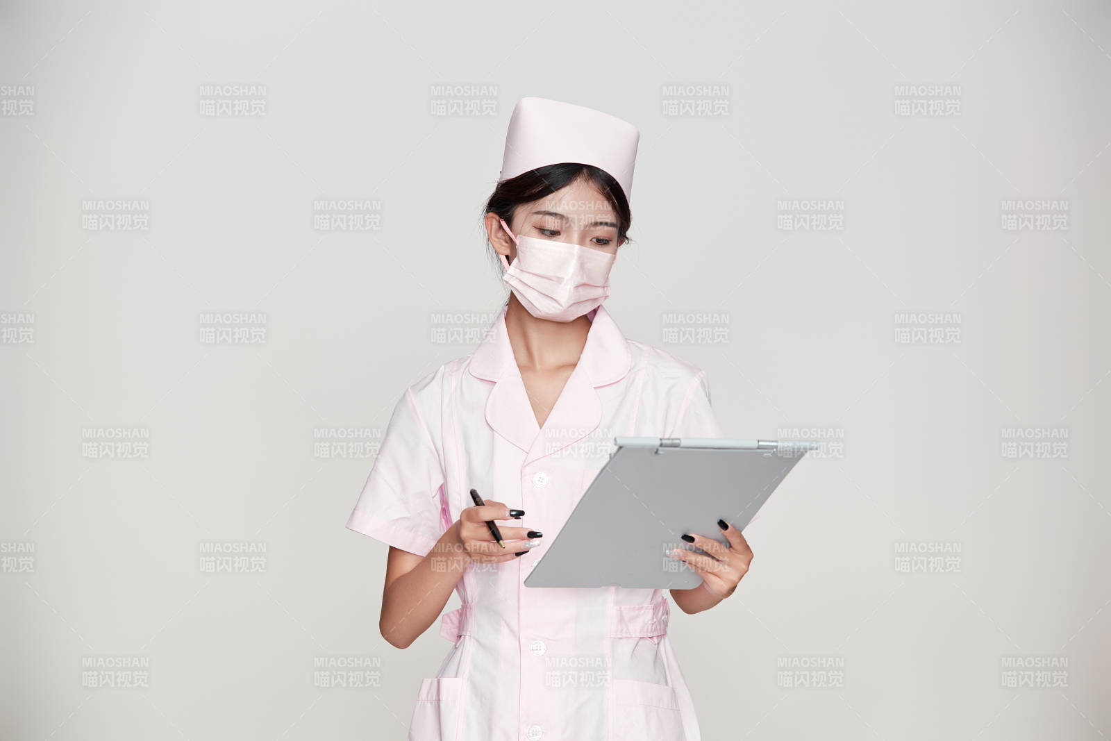 身穿粉色护士服佩戴听诊器的女性医护人员