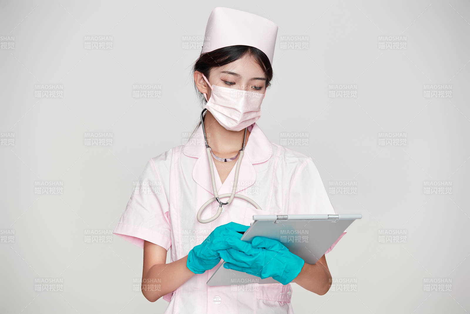 身穿粉色護(hù)士服佩戴聽診器的女性醫(yī)護(hù)人員