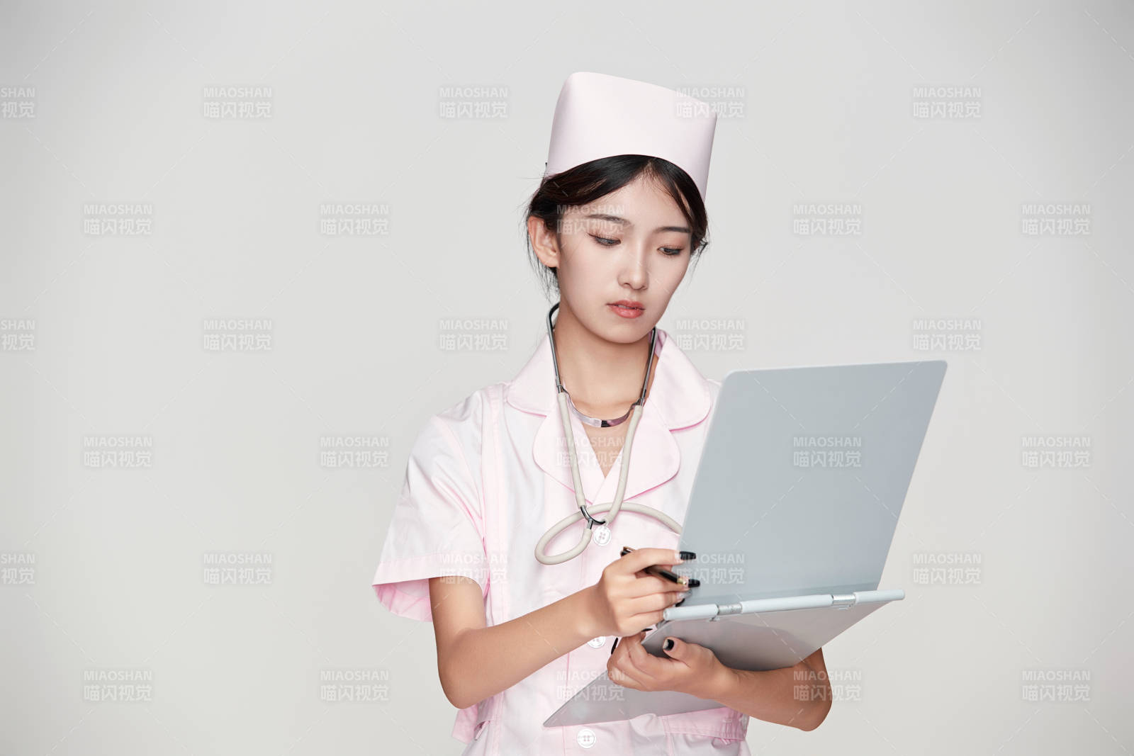 身穿粉色護士服佩戴聽診器的女性醫護人員