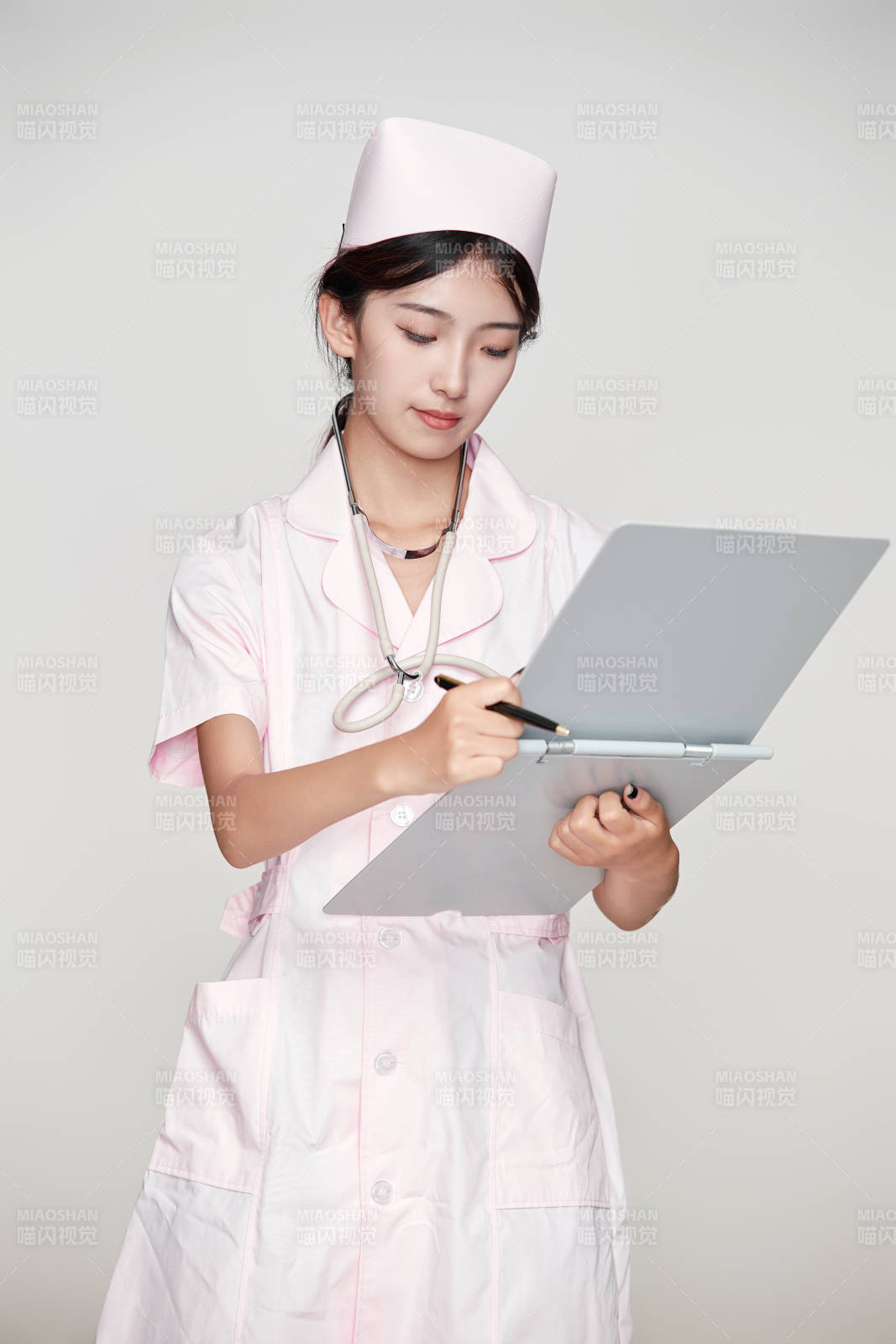 身穿粉色護士服佩戴聽診器的女性醫護人員