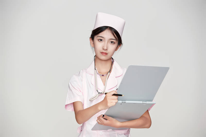 身穿粉色护士服佩戴听诊器的女性医护人员