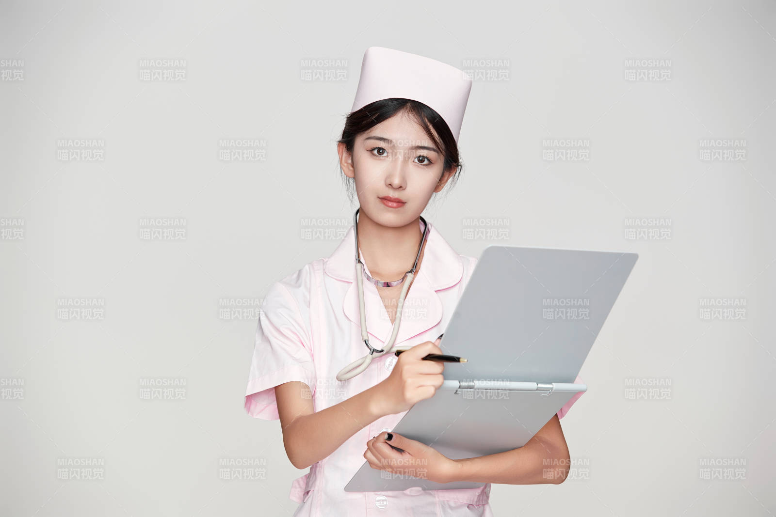 身穿粉色护士服佩戴听诊器的女性医护人员