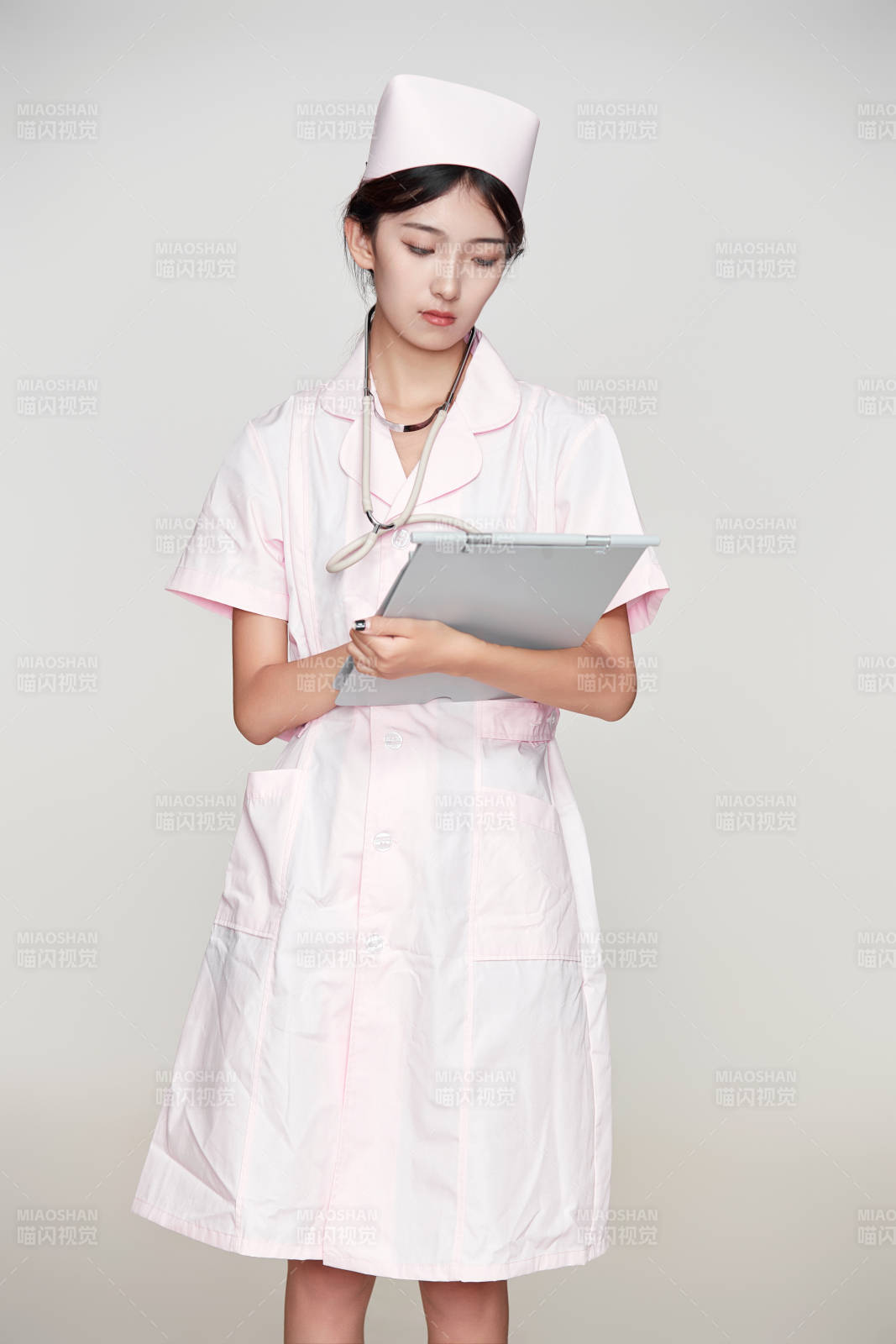 身穿粉色护士服佩戴听诊器的女性医护人员