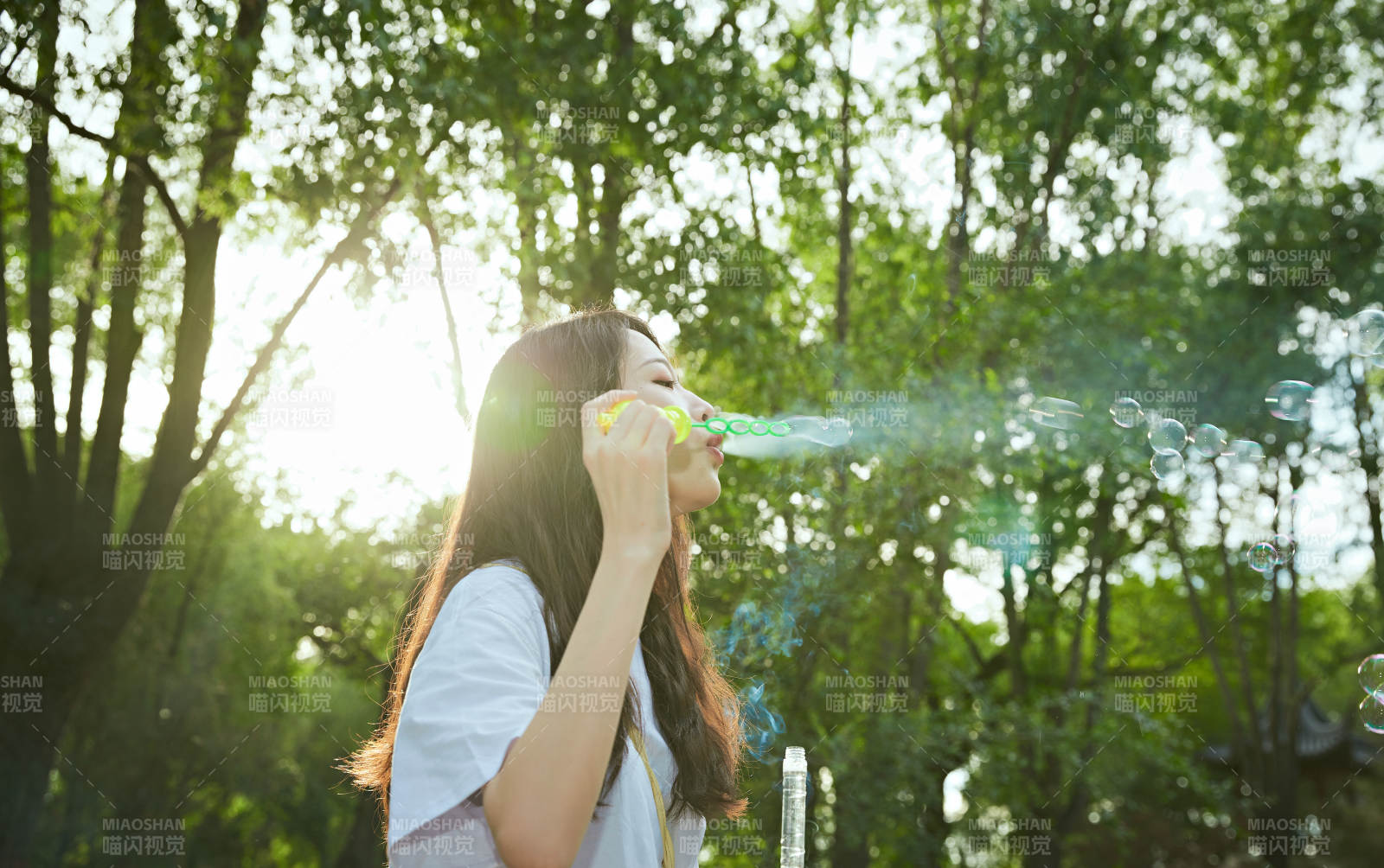 戶外公園里玩吹泡泡的可愛亞洲少女