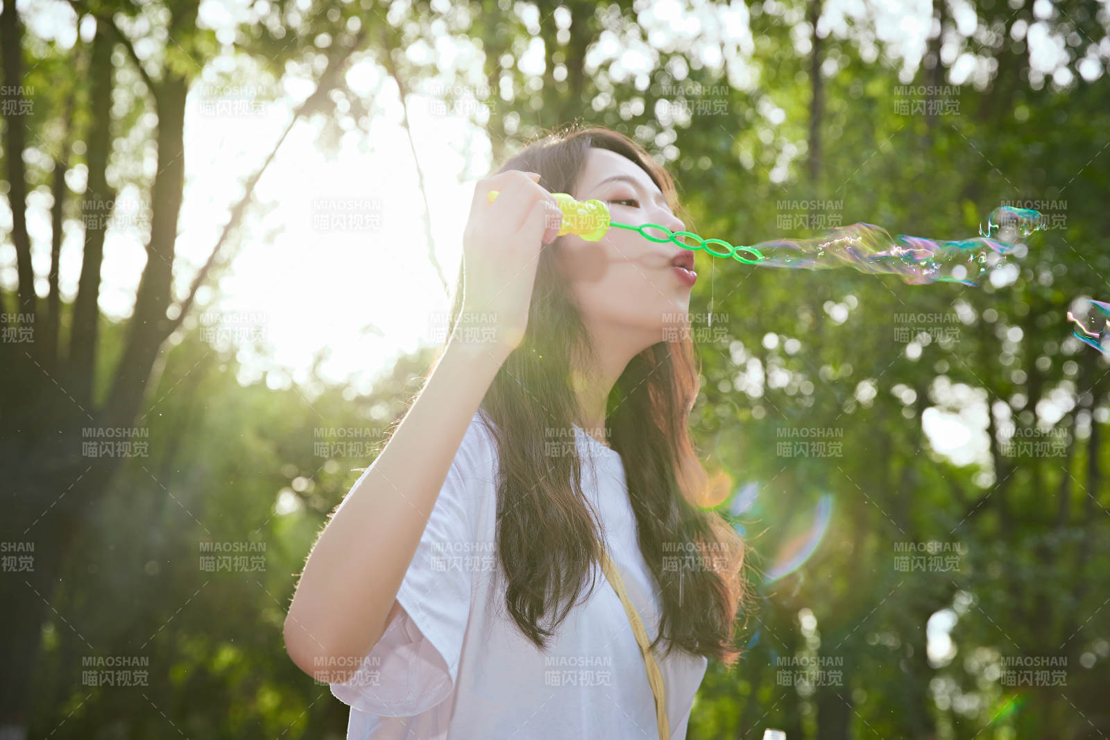 戶外公園里玩吹泡泡的可愛亞洲少女