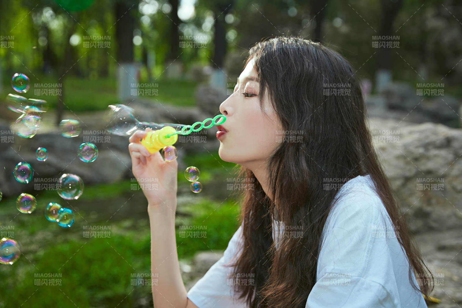 戶外公園里玩吹泡泡的可愛亞洲少女