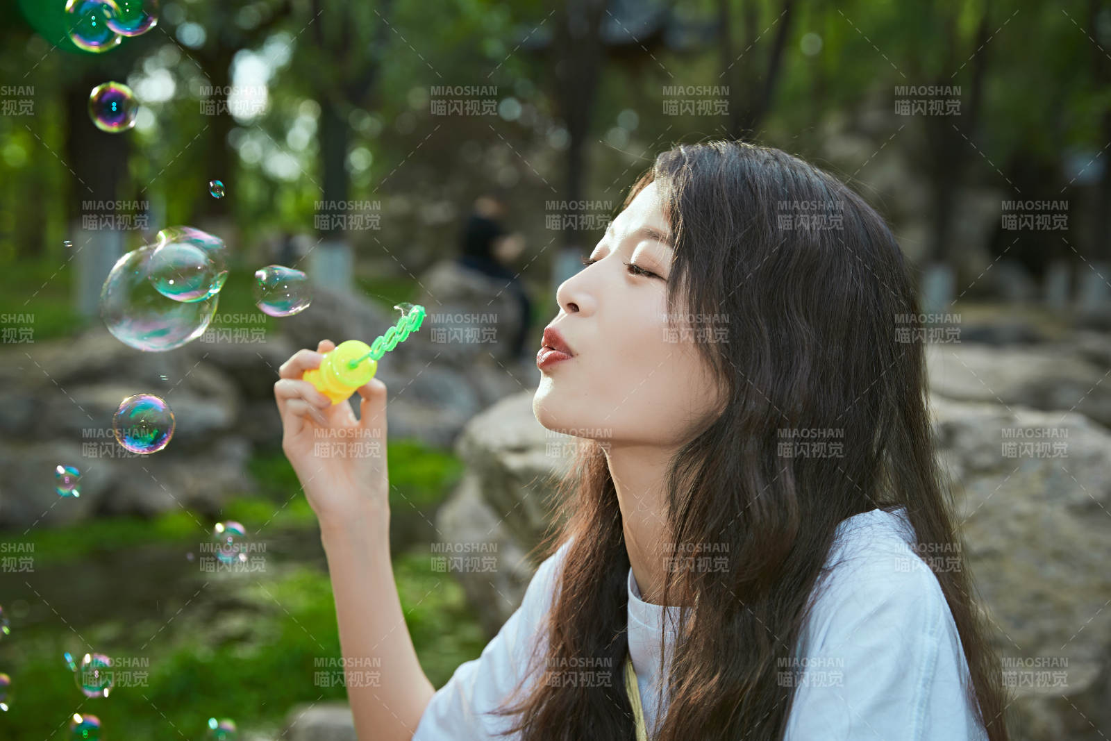 戶外公園里玩吹泡泡的可愛亞洲少女