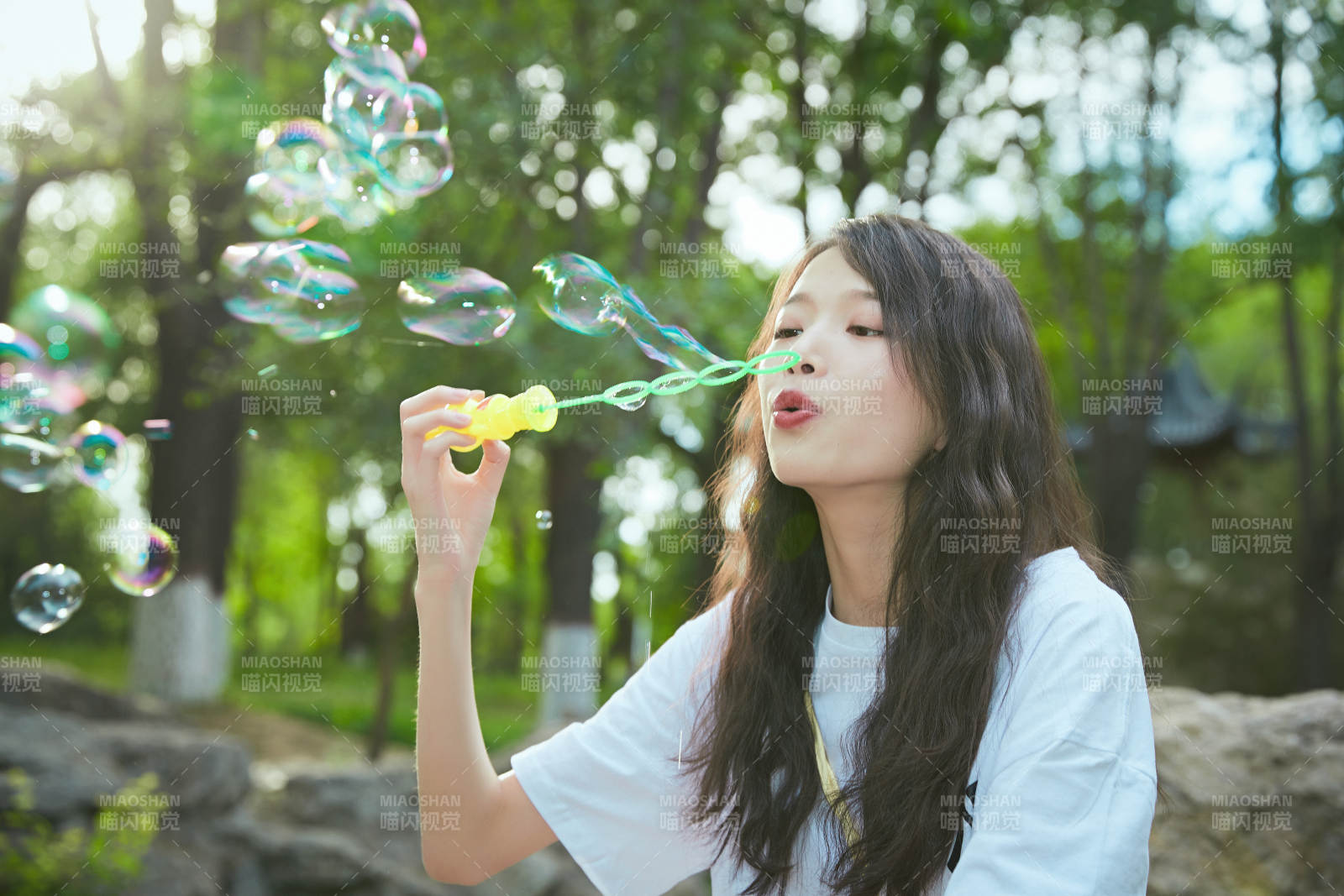 戶外公園里玩吹泡泡的可愛亞洲少女