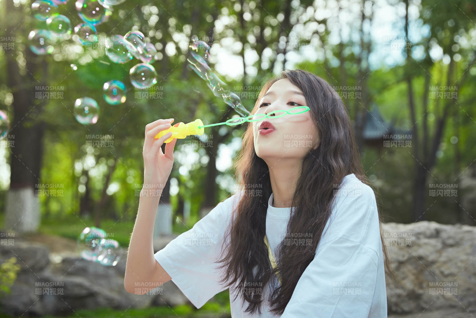 戶外公園里玩吹泡泡的可愛亞洲少女