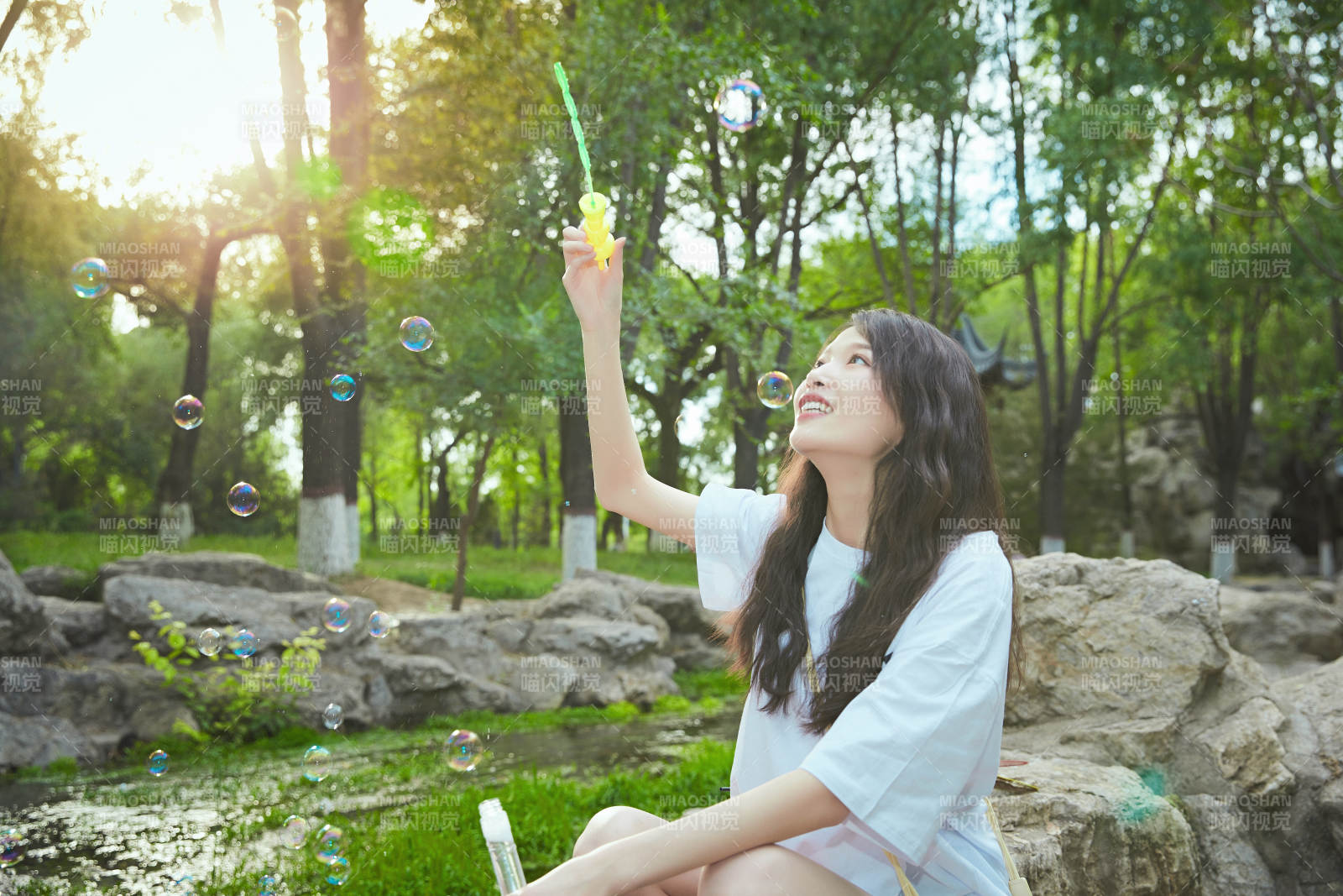 戶外公園里玩吹泡泡的可愛亞洲少女