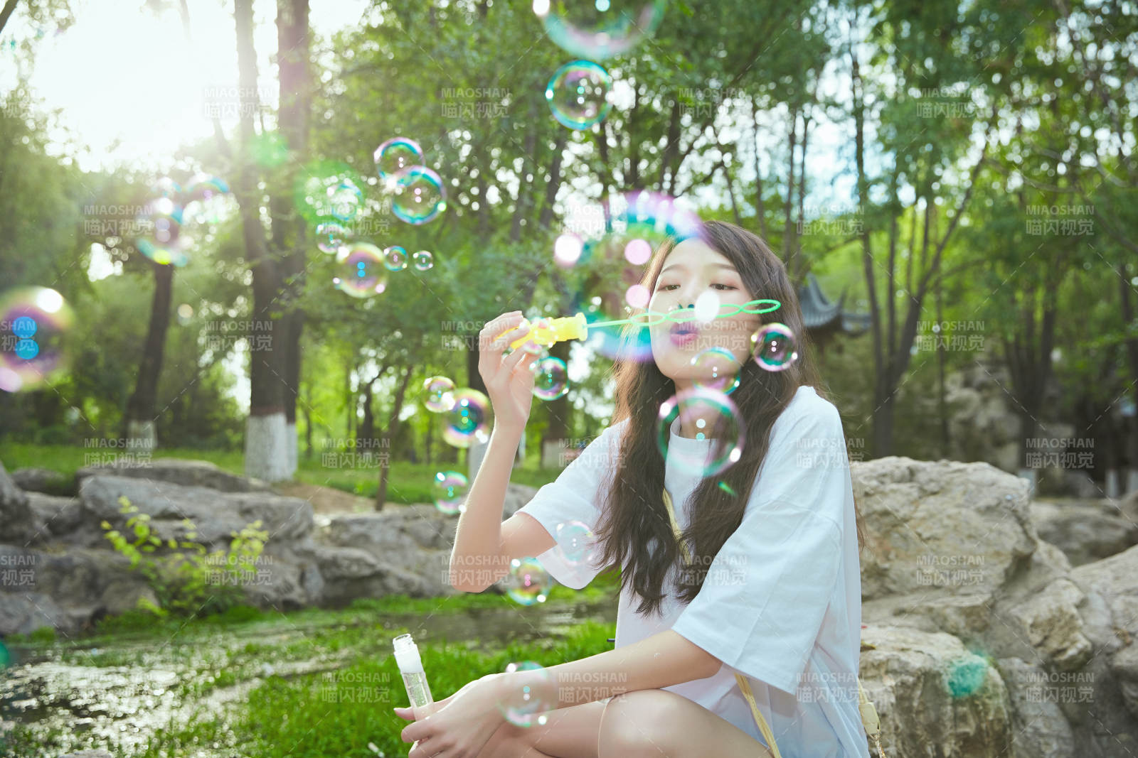 戶外公園里玩吹泡泡的可愛亞洲少女
