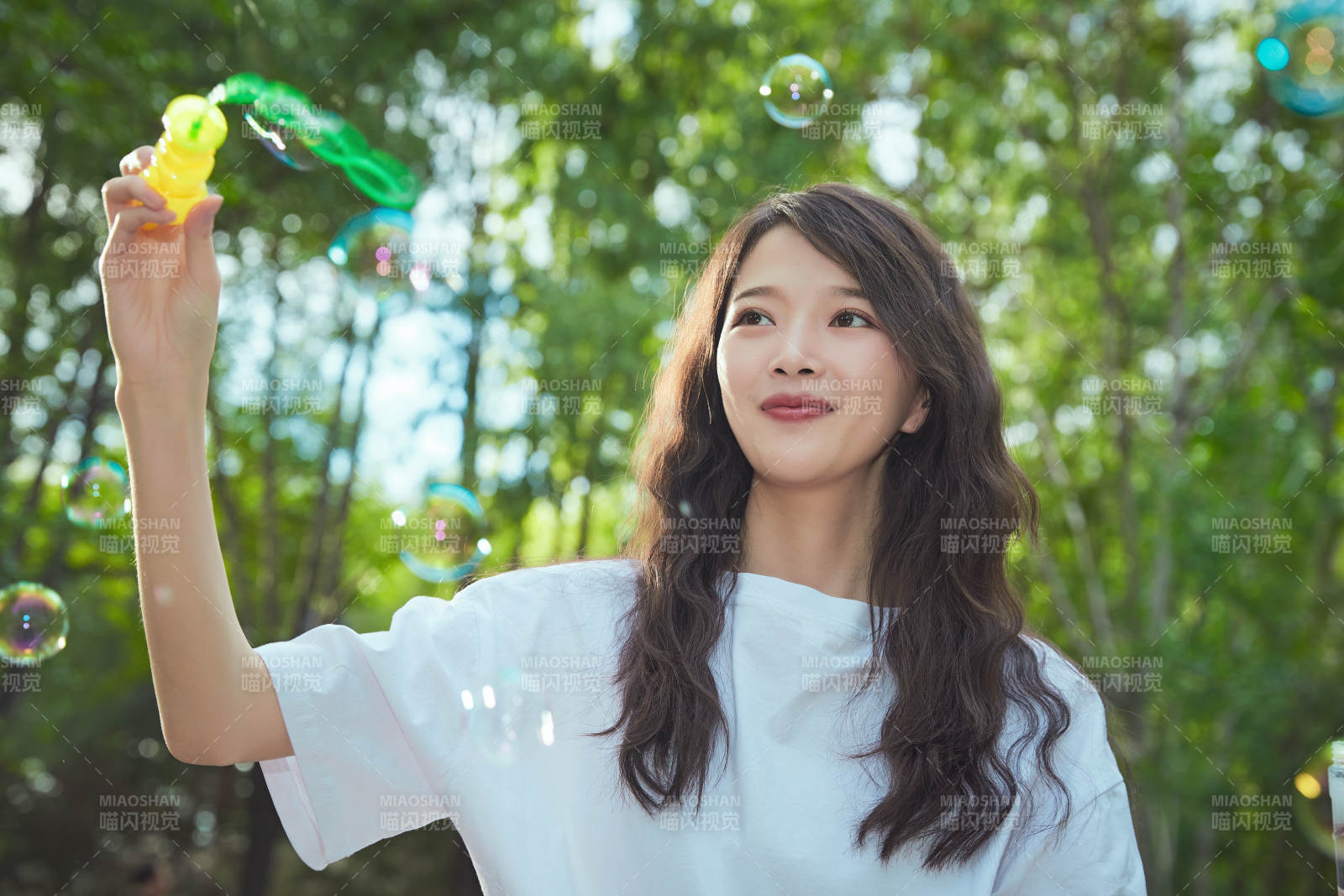 户外公园里玩吹泡泡的可爱亚洲少女