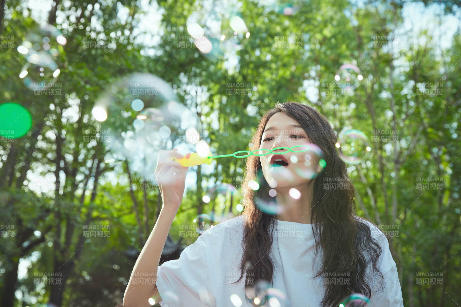 戶外公園里玩吹泡泡的可愛亞洲少女