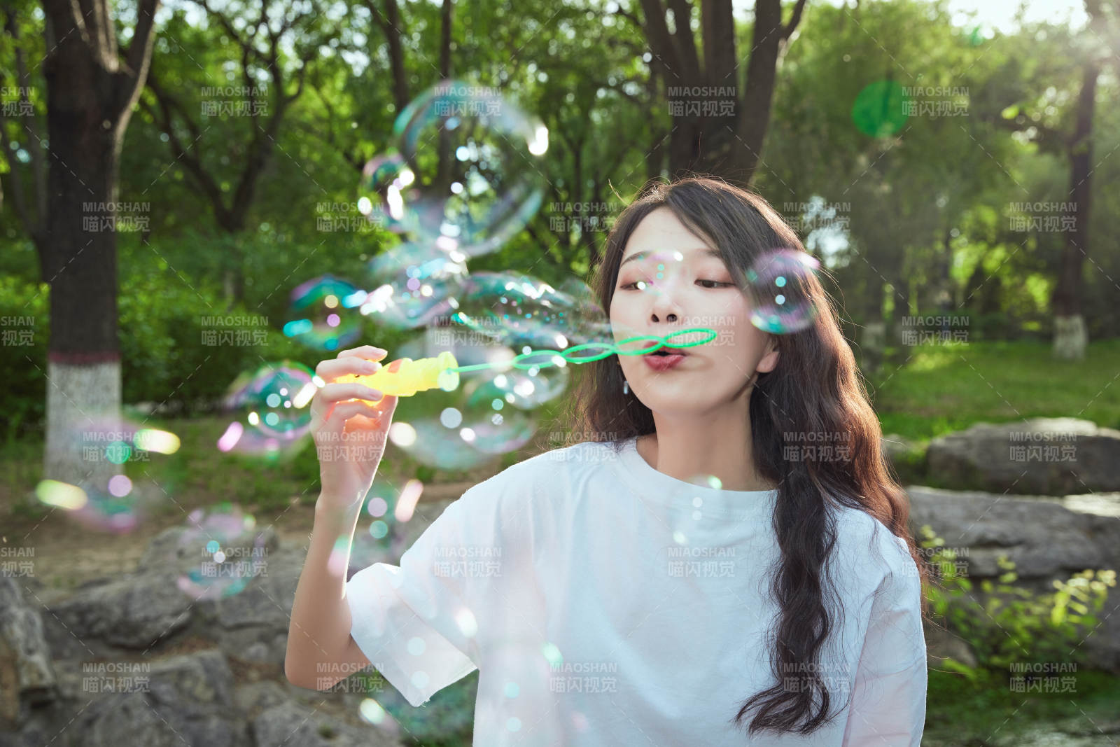 戶外公園里玩吹泡泡的可愛亞洲少女