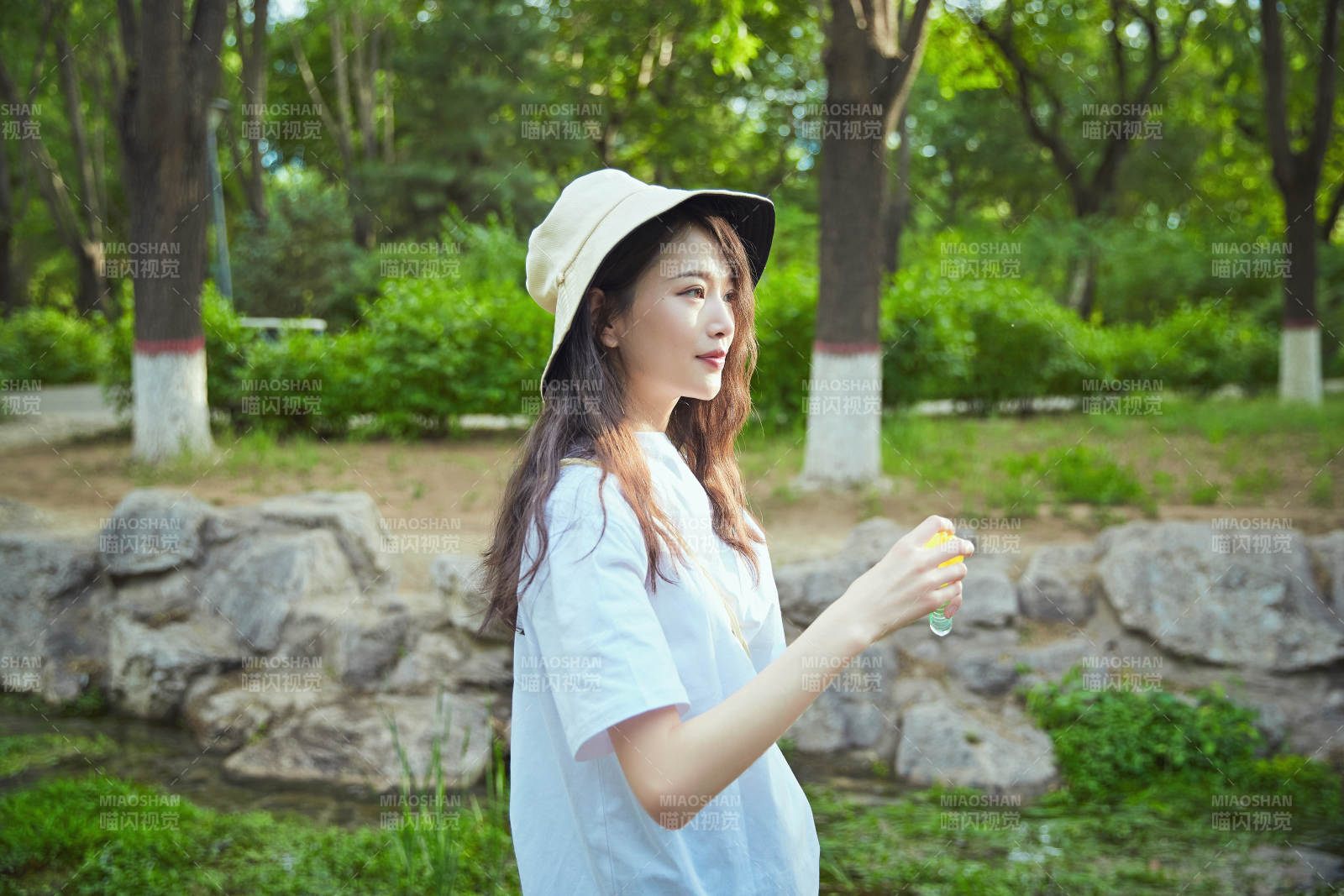 戶外公園里玩吹泡泡的可愛亞洲少女