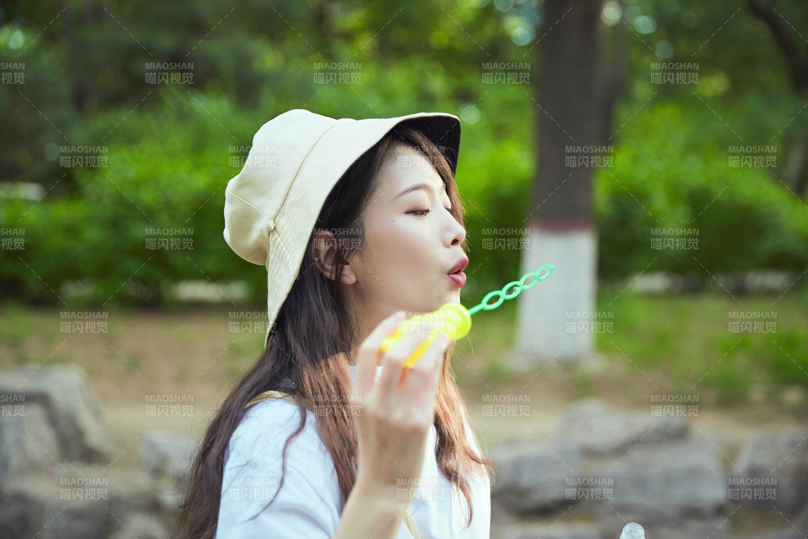 戶外公園里玩吹泡泡的可愛亞洲少女