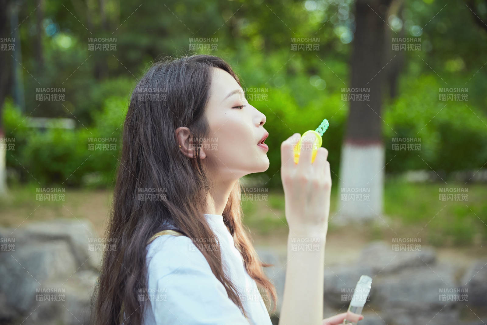 戶外公園里玩吹泡泡的可愛亞洲少女
