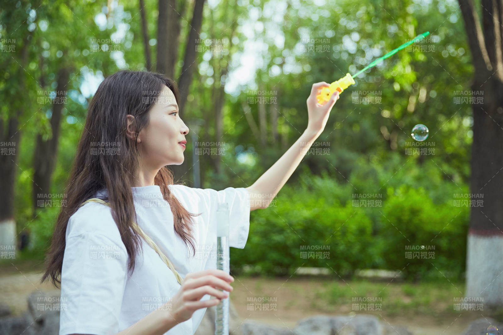 戶外公園里玩吹泡泡的可愛亞洲少女