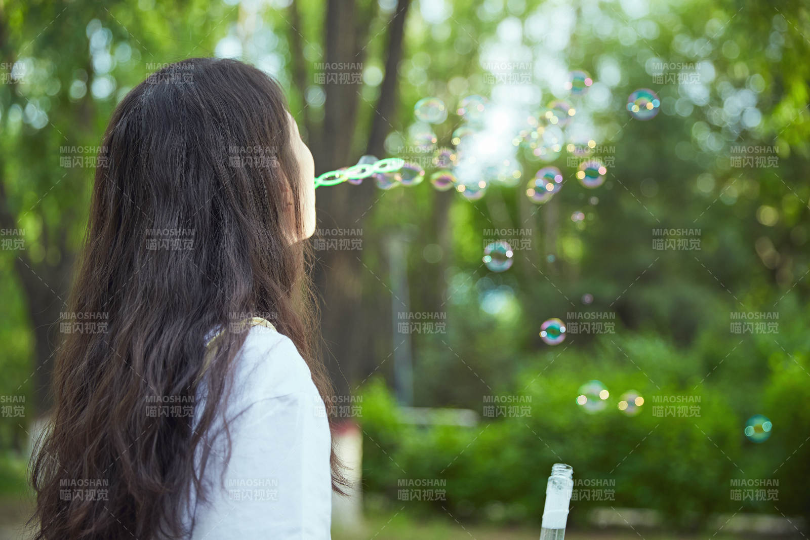 戶外公園里玩吹泡泡的可愛亞洲少女