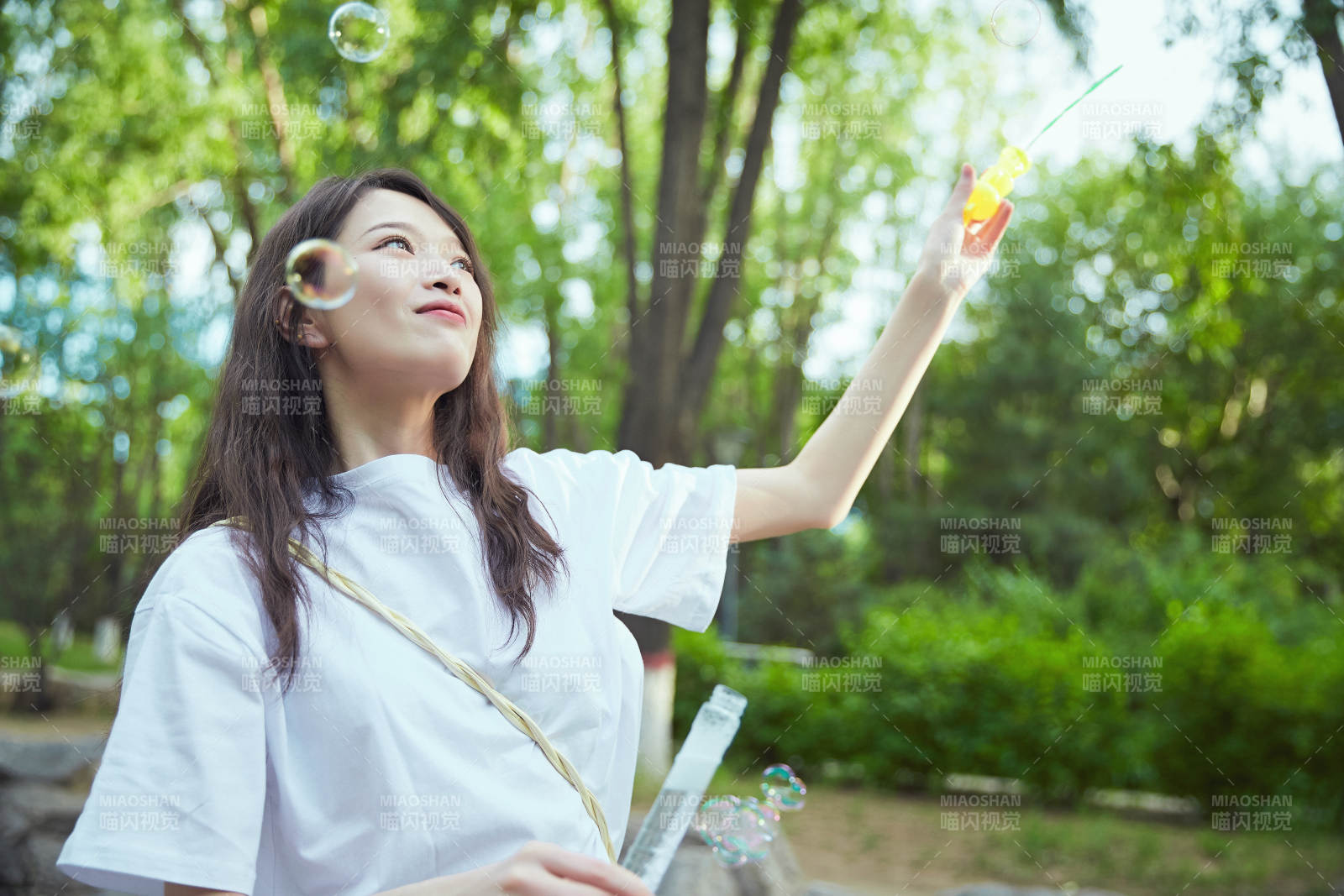 戶外公園里玩吹泡泡的可愛亞洲少女