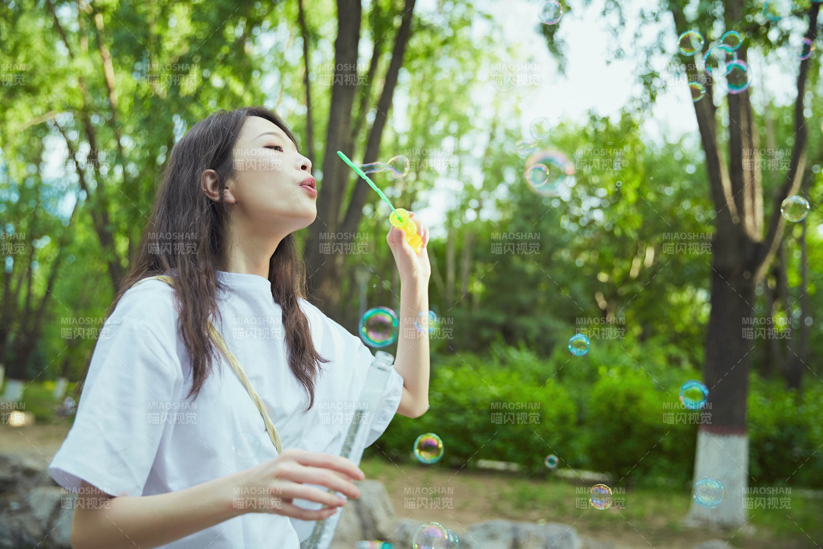 戶外公園里玩吹泡泡的可愛亞洲少女