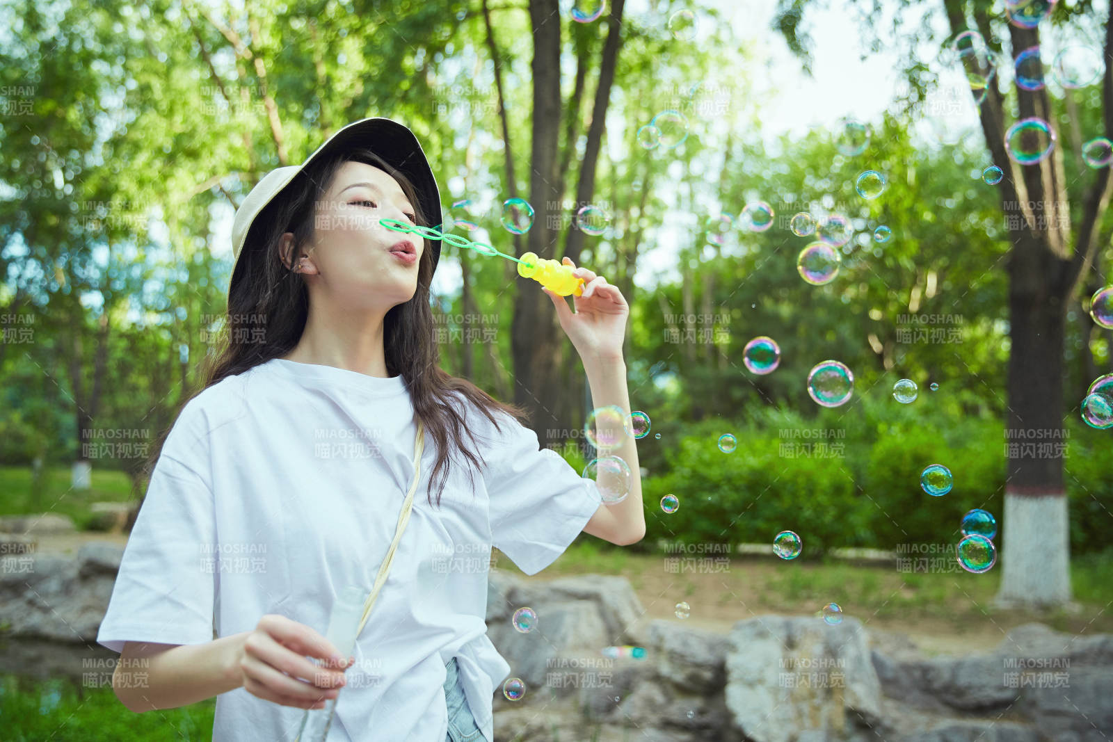 戶外公園里玩吹泡泡的可愛亞洲少女