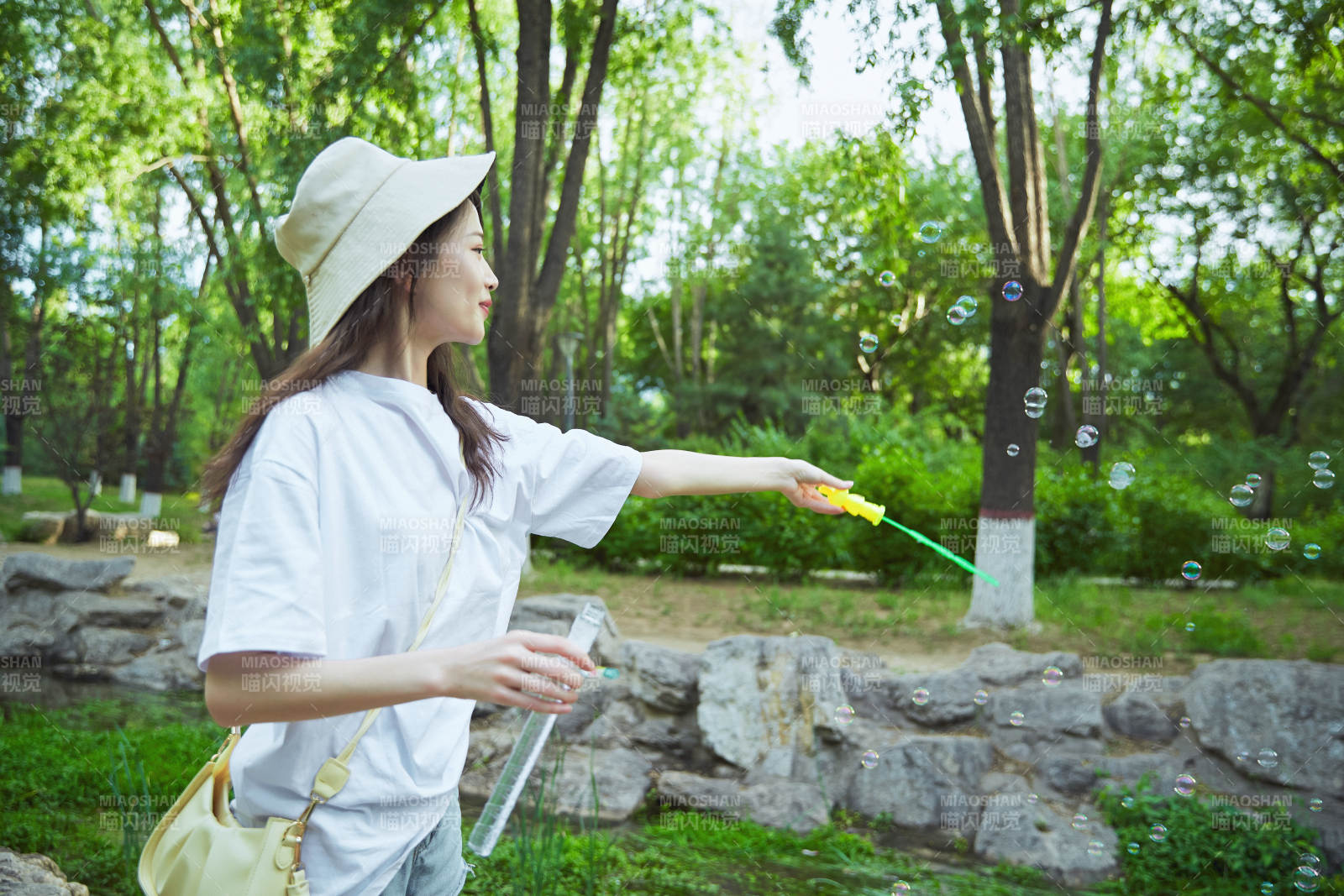 戶外公園里玩吹泡泡的可愛亞洲少女